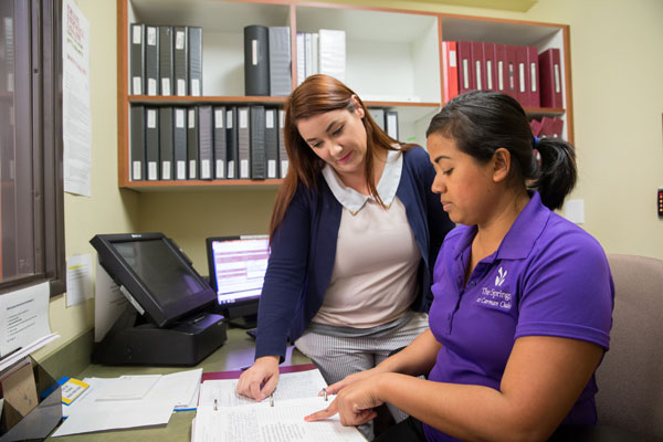 female coworkers looking at a handbook