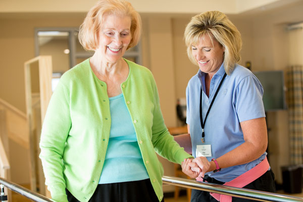 therapist and elderly woman doing physical therapy