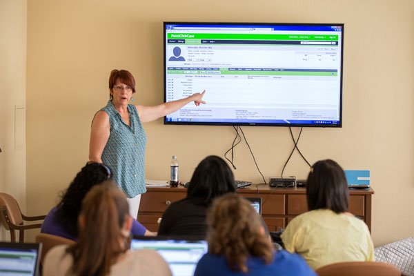Woman giving presentation to class.