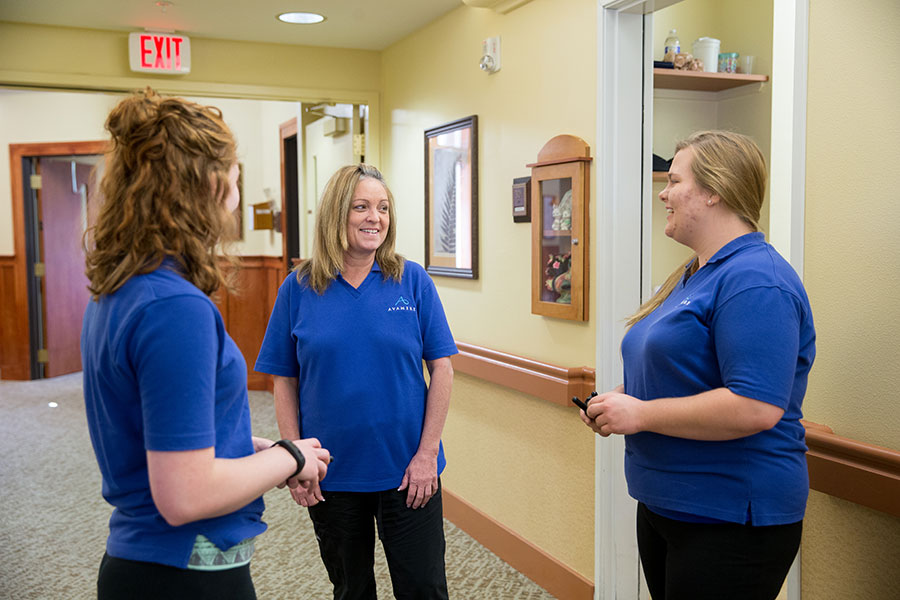 three corworkers talking in the hallway