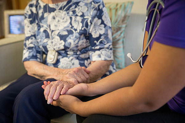closeup of caregiver holding elderly woman's hands