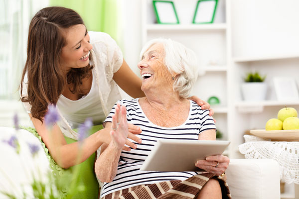 Elderly woman and younger woman laughing together