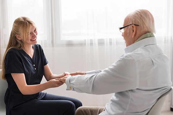 nurse holding senior man's hands